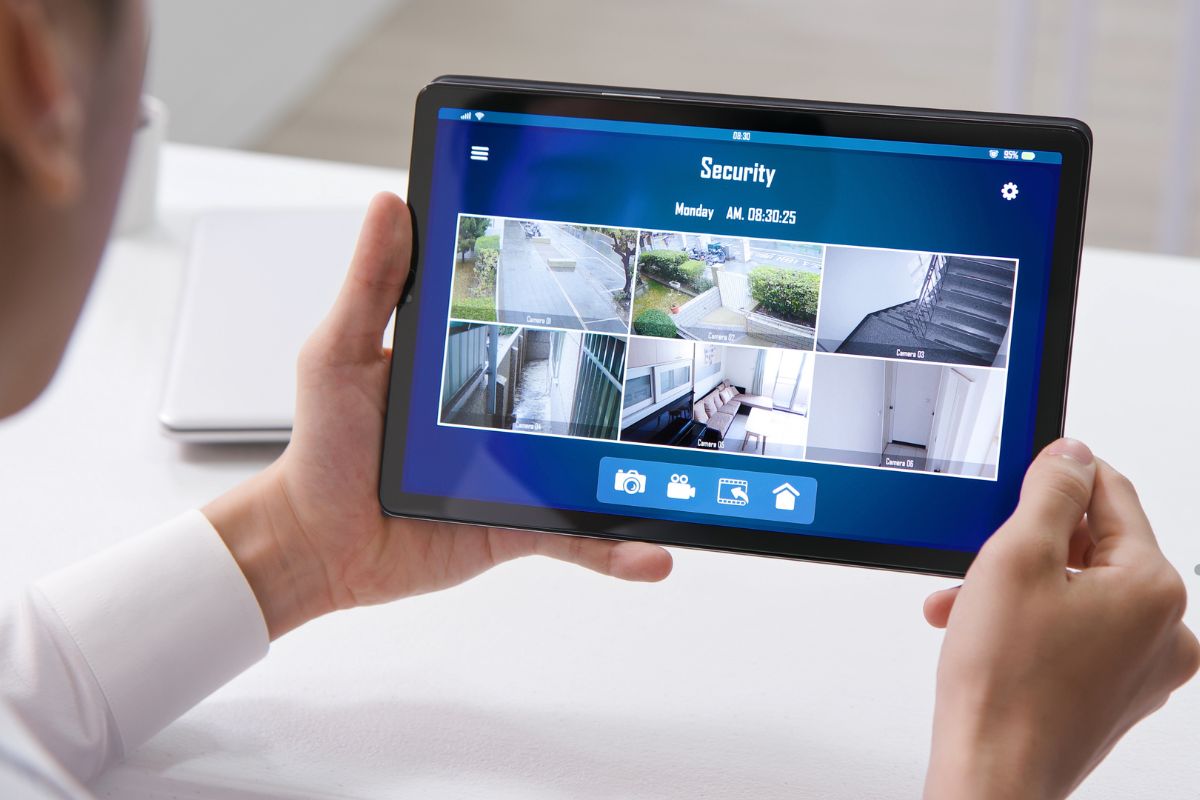 A man displays a tablet showing a security camera, illustrating home security mistakes and solutions.